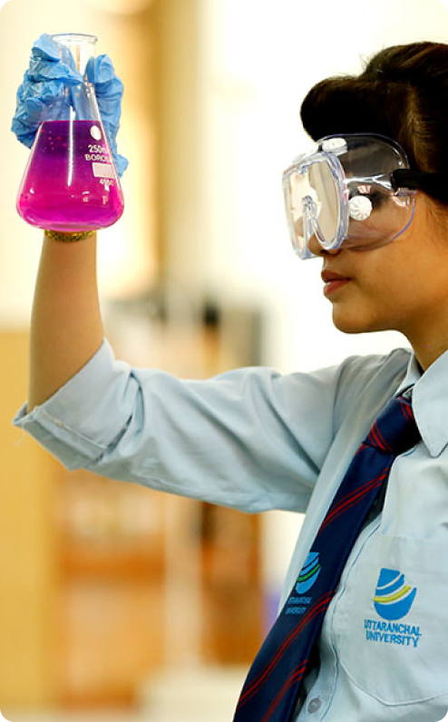 Student holding a flask with pink liquid
