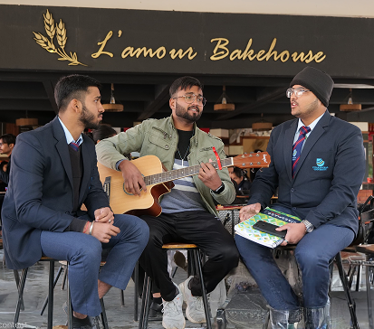 Students playing guitar on campus