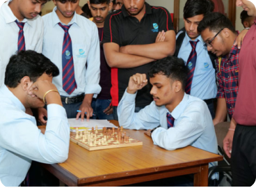 Students focused on a chess game indoors